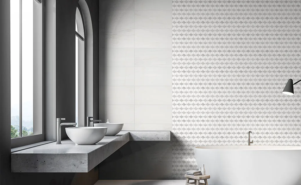 Bianco Dolomite marble and mosaic tile lining a bathroom wall, with twin stone basins on a concrete counter.