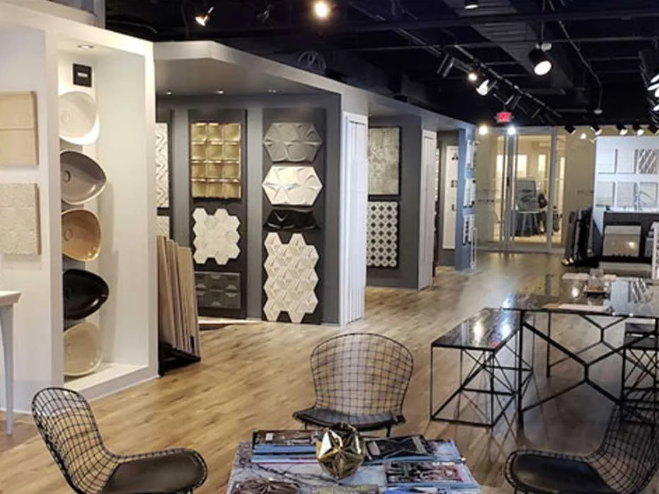 The Atlanta showroom floor: tile and relief panels on display walls, wire chairs and a black glass table on pale timber.