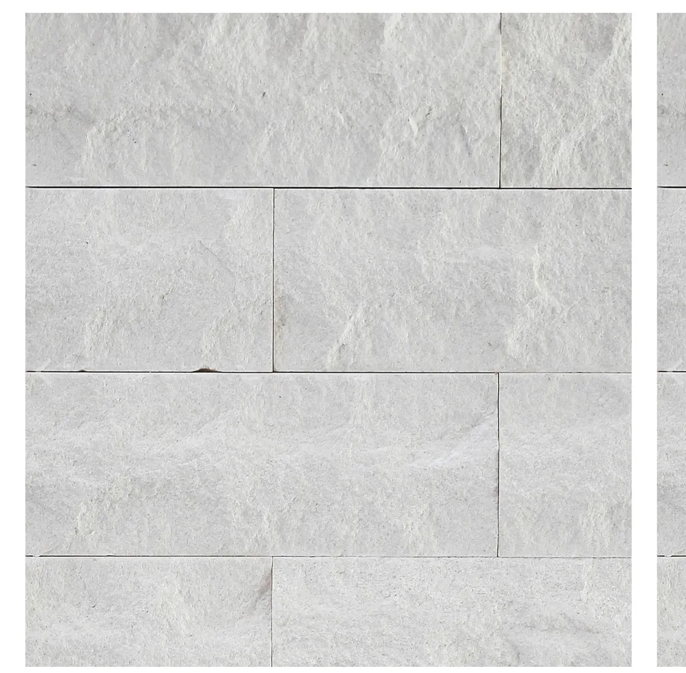 Split-face white marble laid in a running bond, each piece with a rough riven surface.